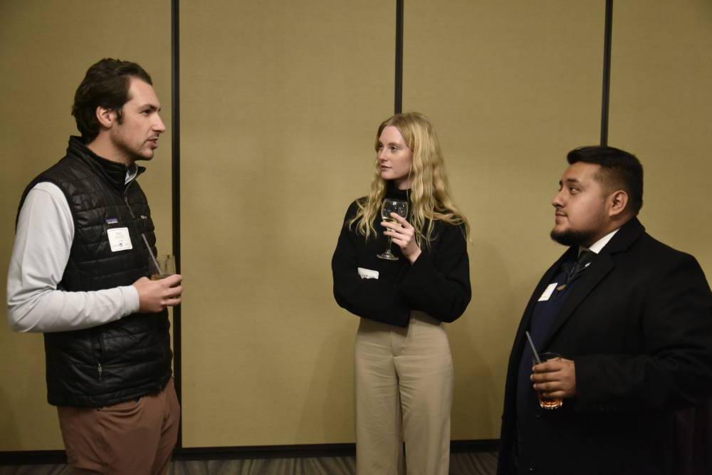 Three Seidman alumni talking at the event.